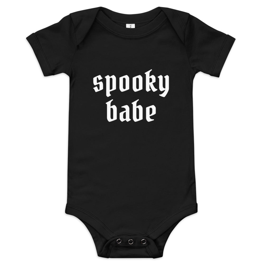 A black baby onesie that says "spooky babe" in a gothic white font