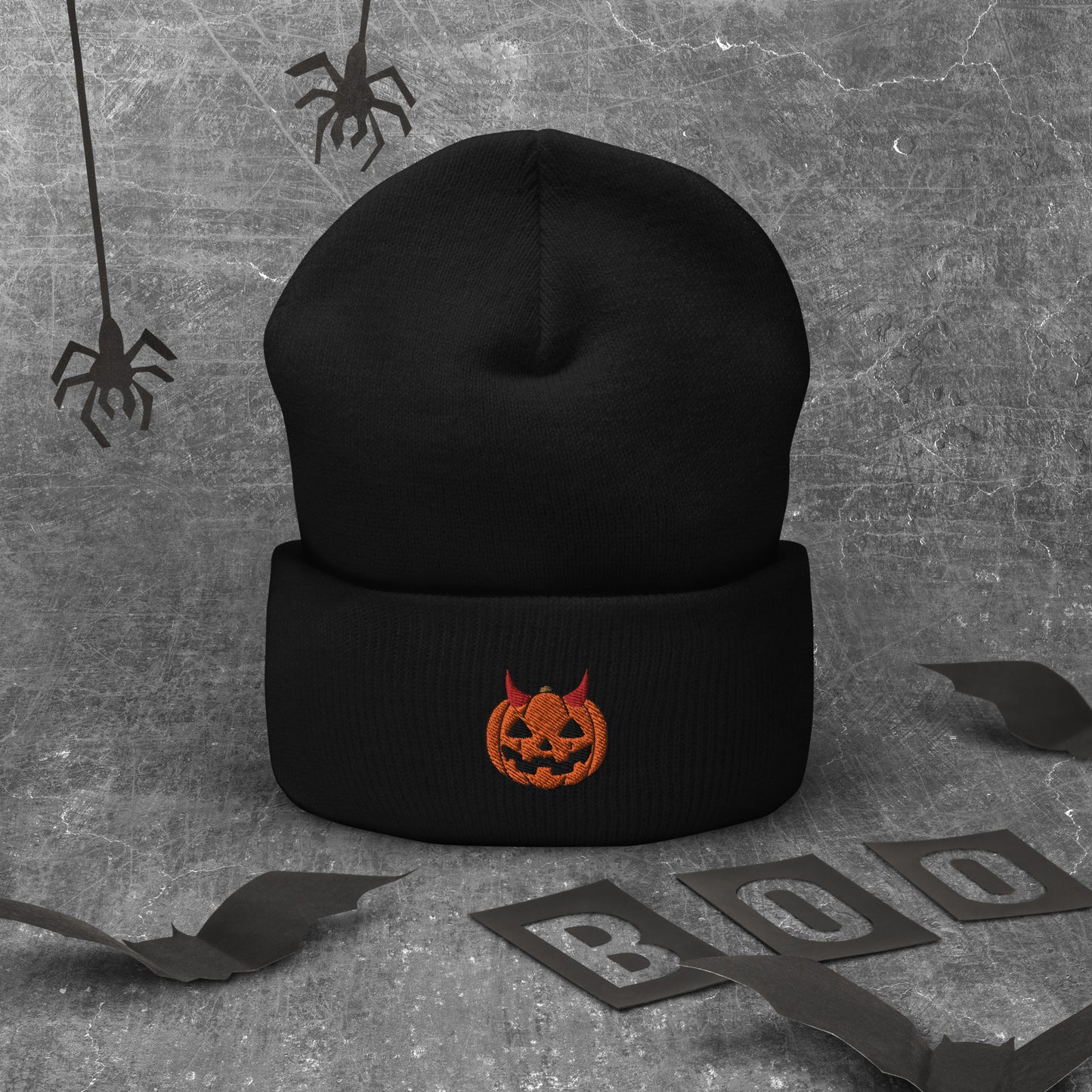 A black cuffed Halloween beanie featuring an embroidered jack-o-lantern wearing devil horns