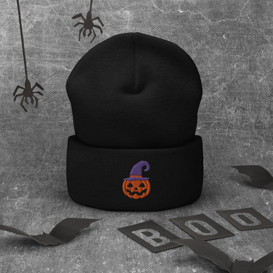 A black cuffed Halloween beanie featuring an embroidered jack-o-lantern wearing a purple witch hat