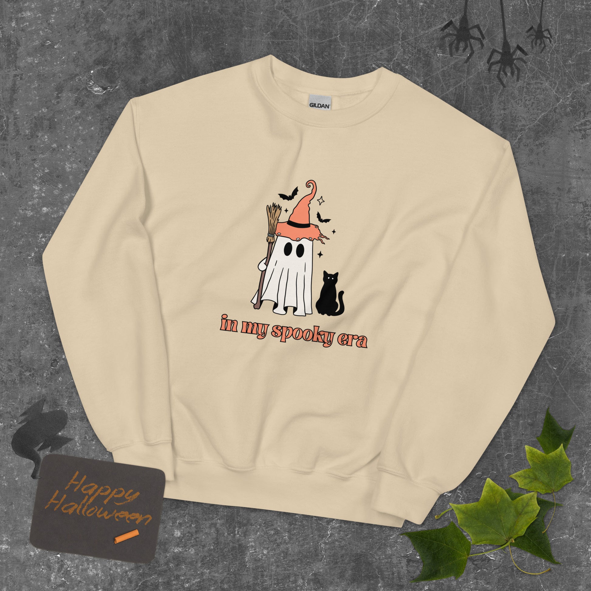 A tan Halloween crewneck sweatshirt, featuring a ghost dressed up like a witch, with the phrase "in my spooky era" underneath