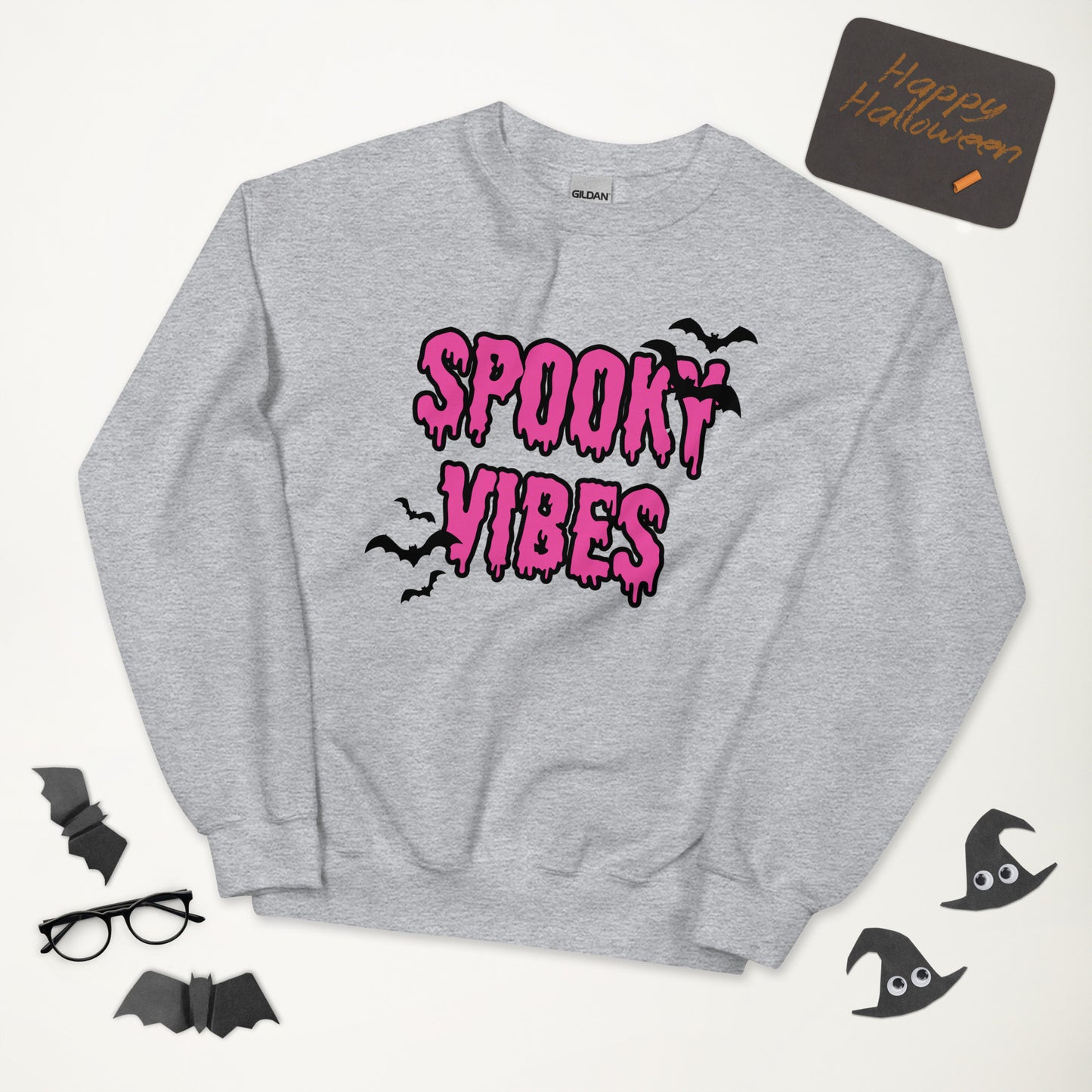 A gray Halloween crewneck sweatshirt that says "spooky vibes" in a creepy, dripping bright pink font, surrounded by bats