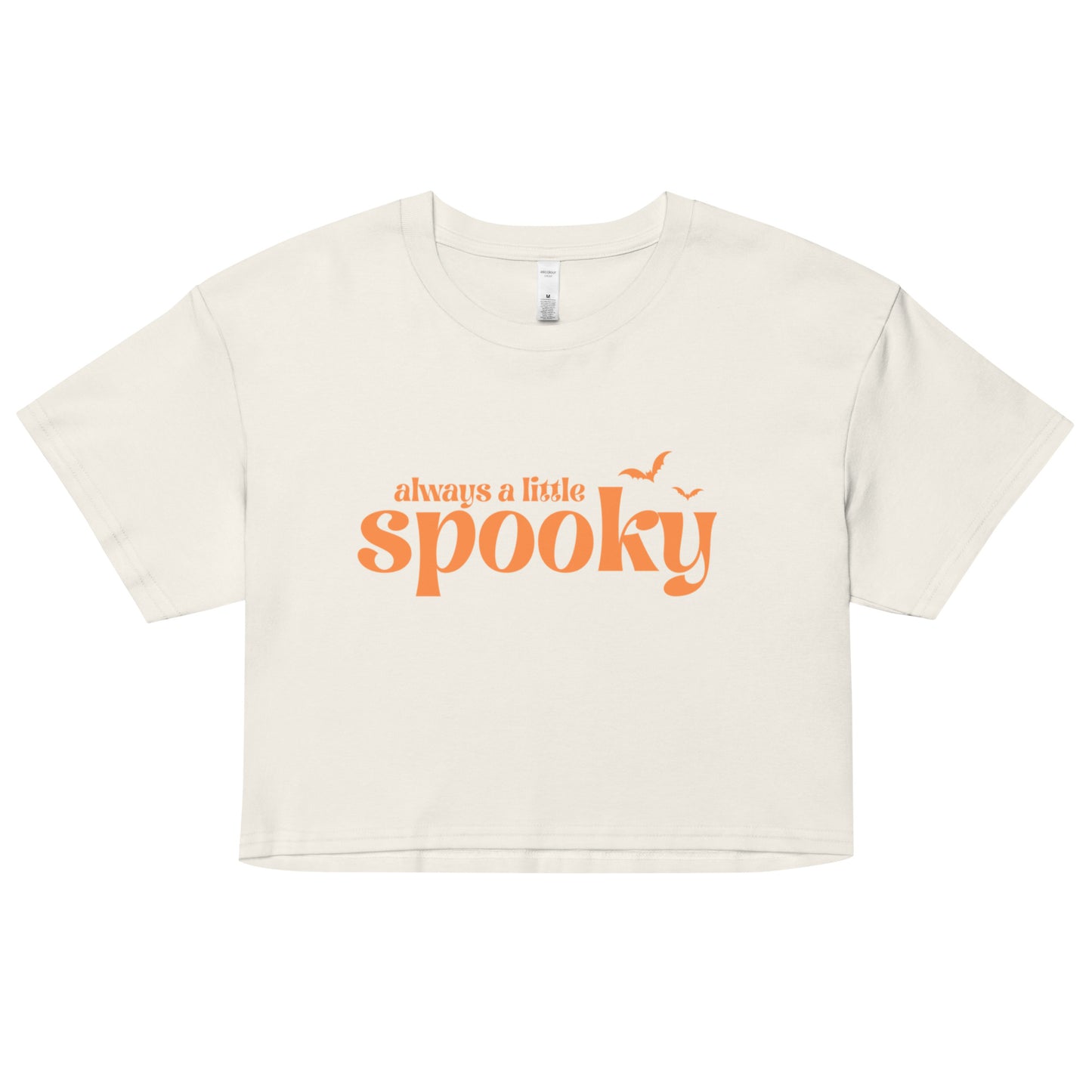An off-white, cropped t-shirt that says "always a little spooky" in a trendy orange font