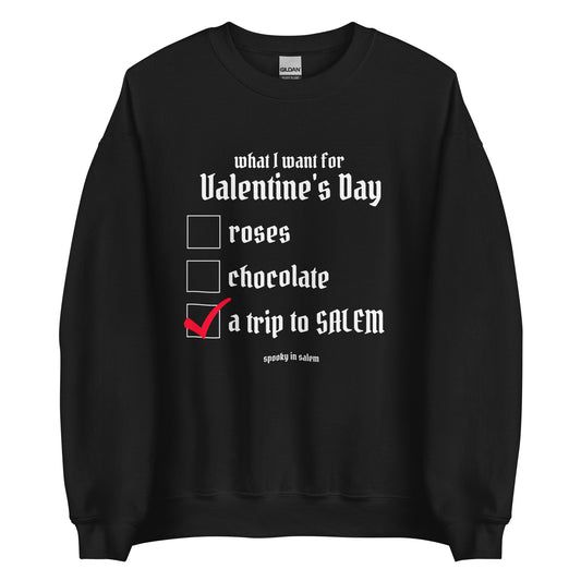 A black crewneck sweatshirt that has a checklist titled What I want for Valentine's Day, with a list of roses, chocolate, and a trip to Salem, next to which is a red check mark