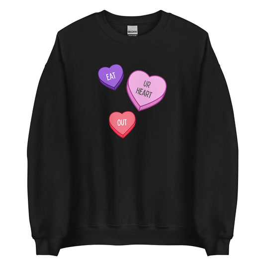 A black crewneck sweatshirt featuring a purple, a pink, and a red candy heart. Together, they say "eat ur heart out."