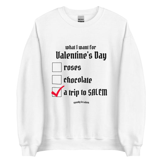 A white crewneck sweatshirt with a checklist in black gothic lettering. The checklist is titled What I Want for Valentine's Day, with a checklist of roses, chocolate, and a trip to Salem, which is checked off in red.